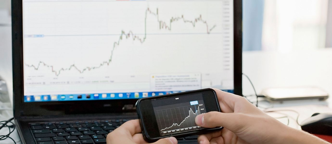 Stock chart on a mobile phone and laptop
