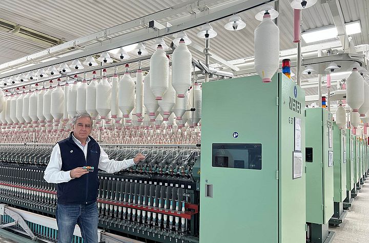 Jordi Ayguasenosa, Manufacturing Director, Aztlán Textil and Azul Textil stands next to the ring spinning machine G 37 equipped with COMPACTeasy.