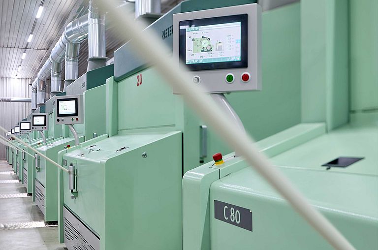 纱厂中的高性能梳棉机C 80，生产的棉条正离开机器。