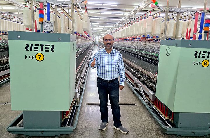 Masood Fabrics Limited Teknik Direktörü Malik Asad Ullah (Eğirme Pozisyonu) Rieter kompakt iplik eğirme K 46 makinesinin önünde duruyor