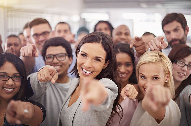 Group of employees pointing at you