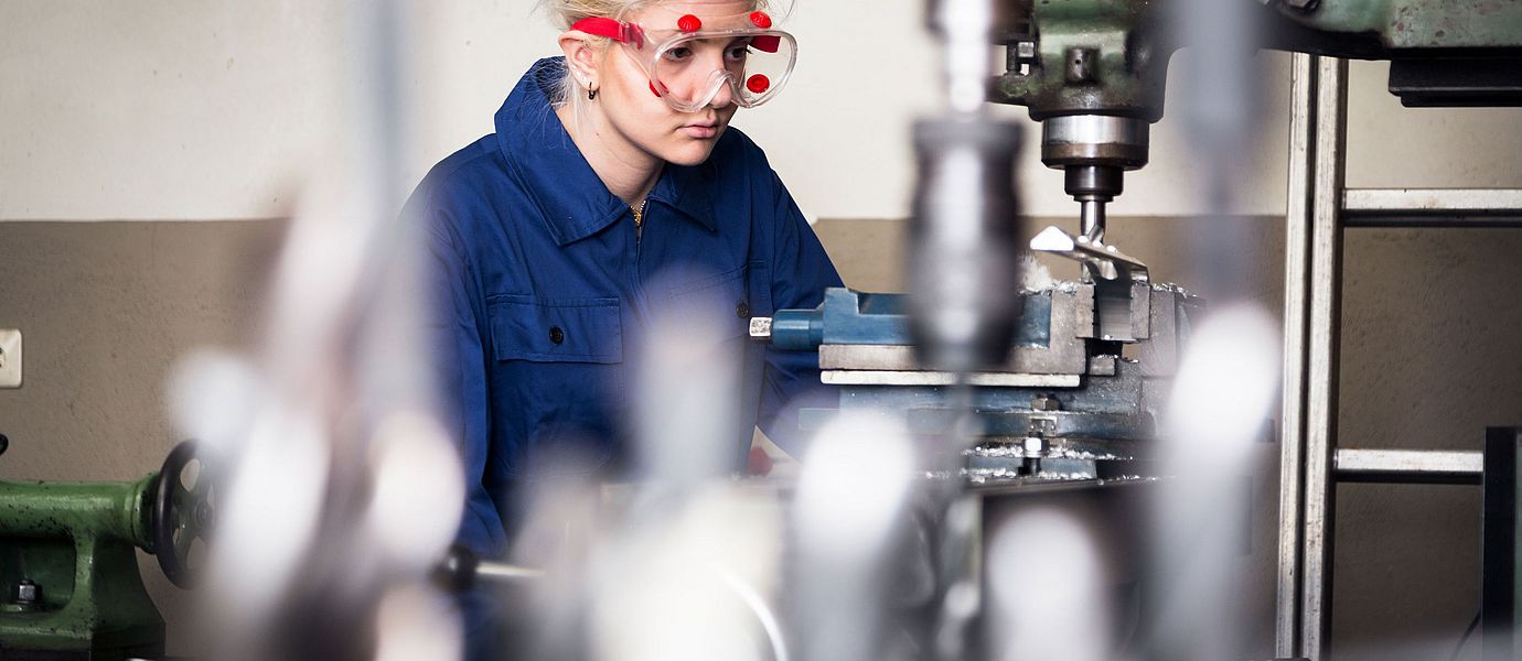 Lehrling arbeitet an einer Fräsmaschine