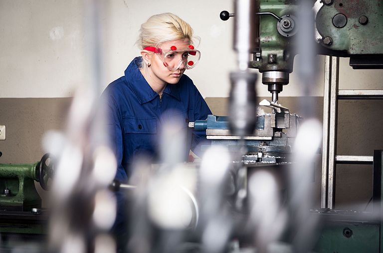 Lehrling arbeitet an einer Fräsmaschine