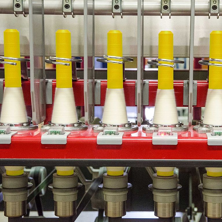 Six spinning positions of a ring spinning machine with LEDs at each spinning position. One LED lights up red.