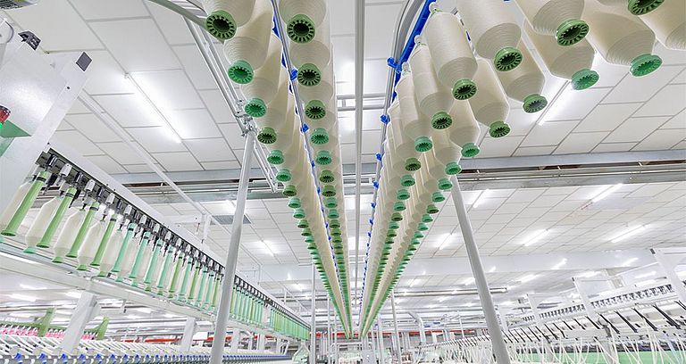 Roving bobbins hang overhead in a roving bobbin transport system