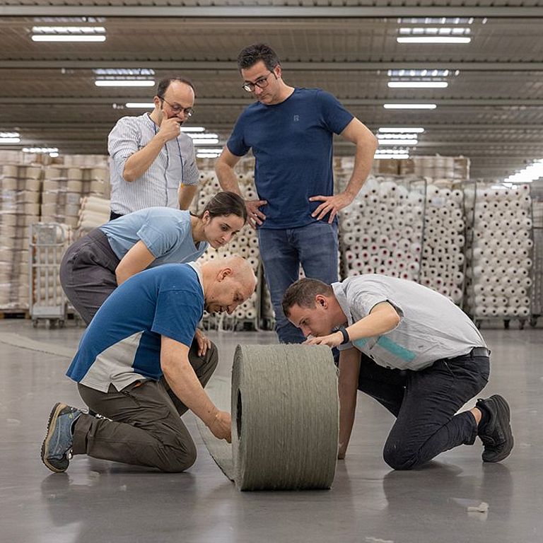 Das Team prüft den Wickel der Kämmmaschine auf Gleichmässigkeit