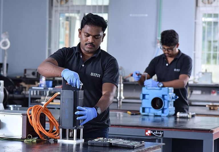 In a Rieter repair service center, two employees repair various products.