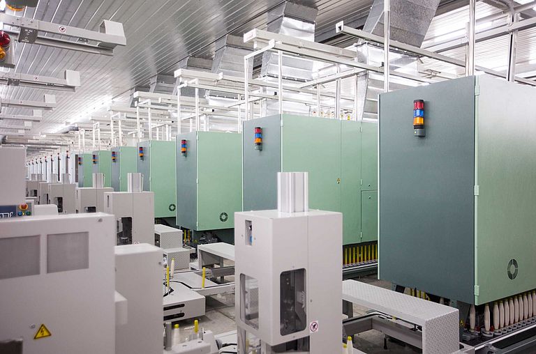 Otomatik kops taşıma sistemiyle bir bobin makinasına bağlı bir iplikhanedeki birçok ring iplik makinası