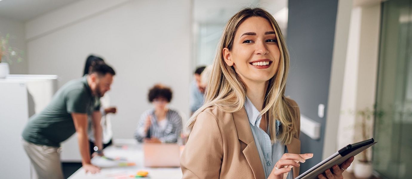 Happy white collar worker holding a tablet