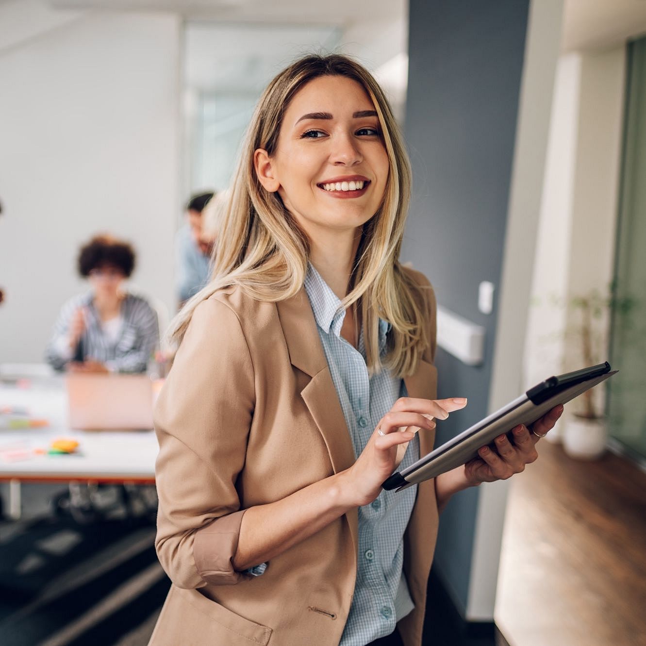 Happy white collar worker holding a tablet