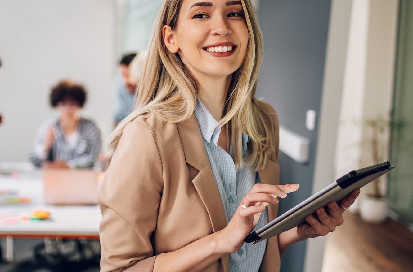 Happy white collar worker holding a tablet